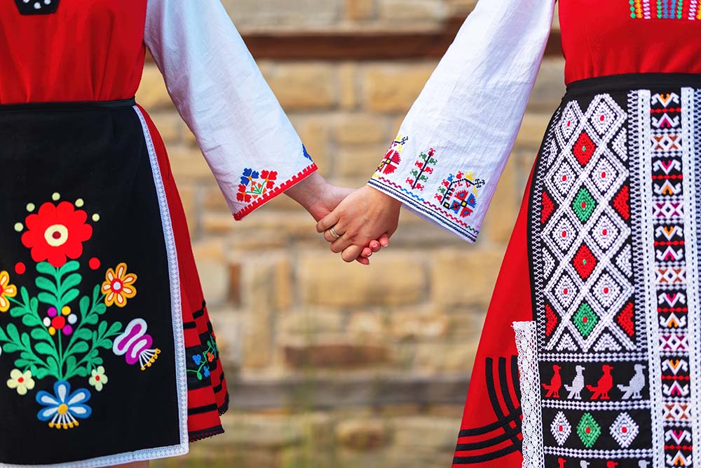 Mädchen in traditionellen bulgarischen ethnischen Kostümen mit Volksstickereien
