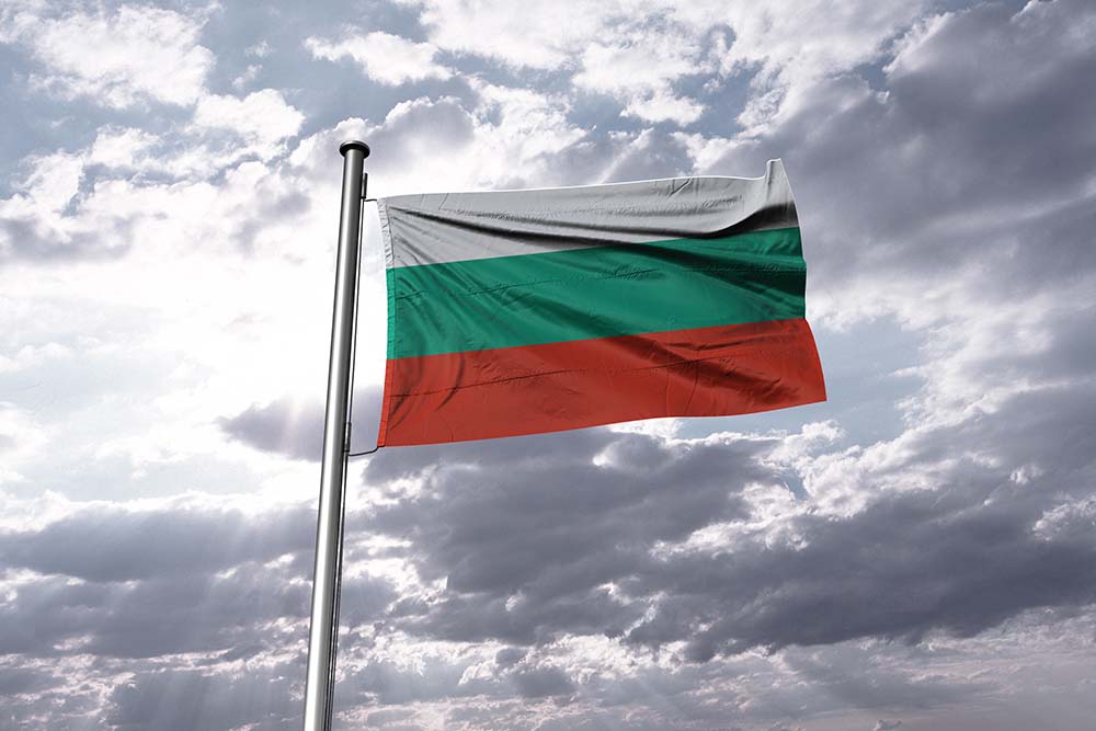 Bulgarische Flagge vor bewölktem Himmel.