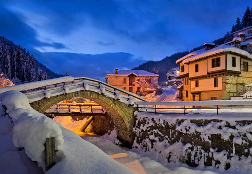 Schneebedeckte Steinbrücke im Dorf Shiroka-Lyk
