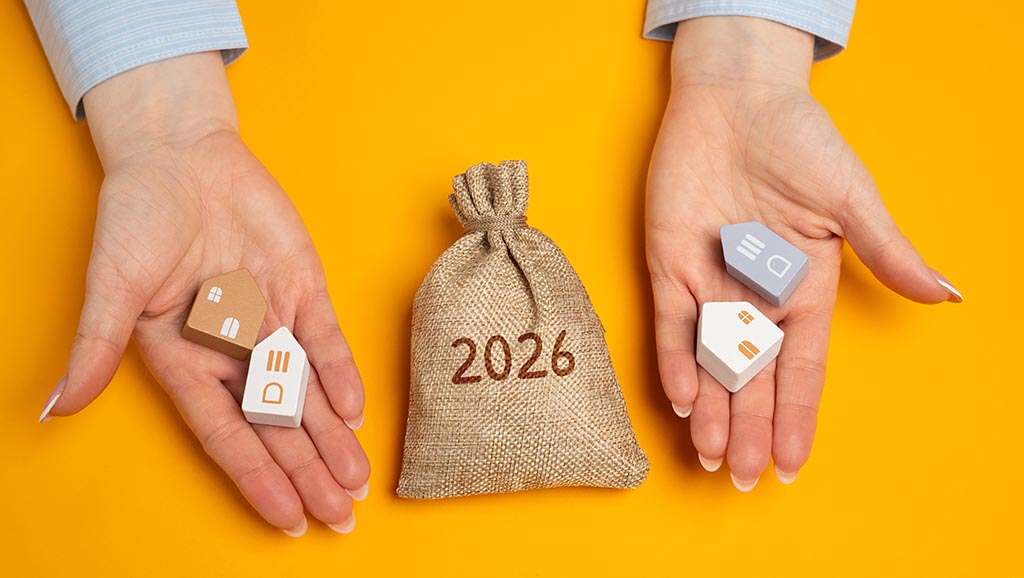 Hände halten Hausmodelle und einen Geldsack, die finanzielle Aspekte des Immobilienerwerbs in Bulgarien darstellen