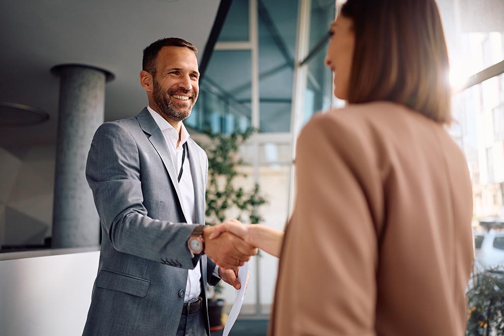 Ein Mann und eine Frau geben sich die Hand und besiegeln die offizielle Vereinbarung zum Kauf einer Immobilie in Bulgarien